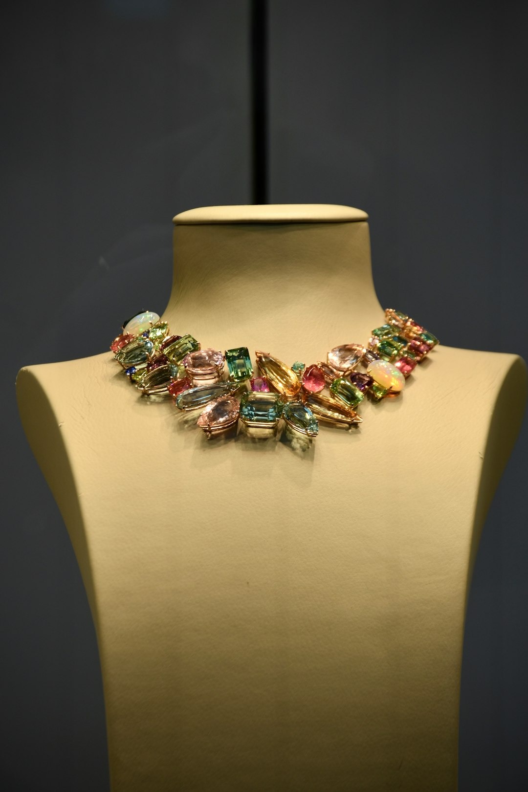 Multi-gemstone necklace displayed on a mannequin bust.